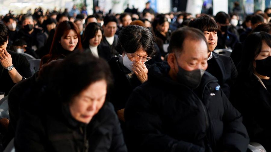 Para anggota keluarga yang berduka bereaksi selama upacara peringatan satu tahun kecelakaan pesawat Jeju Air yang menewaskan 179 orang, di Bandara Internasional Muan di Muan, Korea Selatan, 29 Desember 2025. (REUTERS/Kim Soo-hyeon)