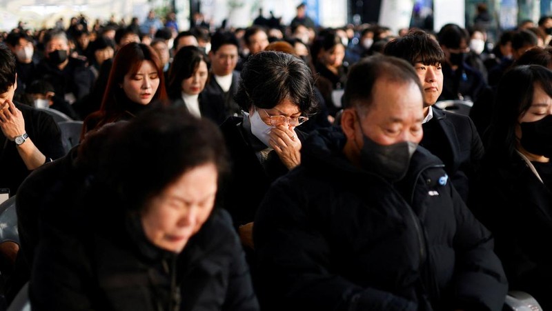 Para anggota keluarga yang berduka bereaksi selama upacara peringatan satu tahun kecelakaan pesawat Jeju Air yang menewaskan 179 orang, di Bandara Internasional Muan di Muan, Korea Selatan, 29 Desember 2025. (REUTERS/Kim Soo-hyeon)