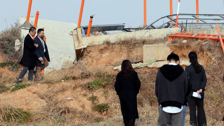 Para anggota keluarga yang berduka bereaksi selama upacara peringatan satu tahun kecelakaan pesawat Jeju Air yang menewaskan 179 orang, di Bandara Internasional Muan di Muan, Korea Selatan, 29 Desember 2025. (REUTERS/Kim Soo-hyeon)
