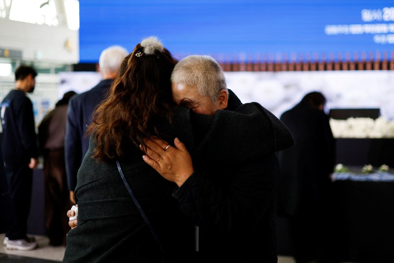 Para anggota keluarga yang berduka bereaksi selama upacara peringatan satu tahun kecelakaan pesawat Jeju Air yang menewaskan 179 orang, di Bandara Internasional Muan di Muan, Korea Selatan, 29 Desember 2025. (REUTERS/Kim Soo-hyeon)