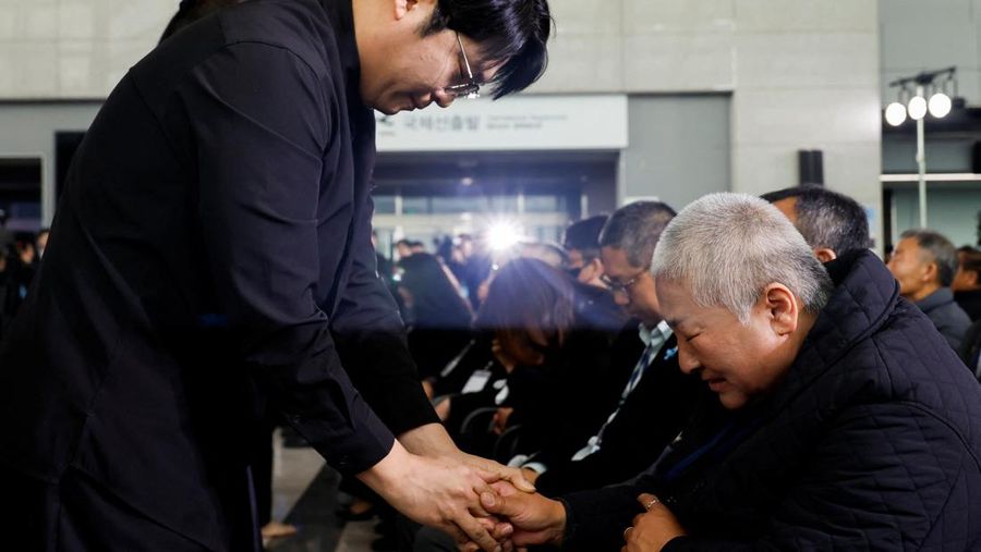 Para anggota keluarga yang berduka bereaksi selama upacara peringatan satu tahun kecelakaan pesawat Jeju Air yang menewaskan 179 orang, di Bandara Internasional Muan di Muan, Korea Selatan, 29 Desember 2025. (REUTERS/Kim Soo-hyeon)