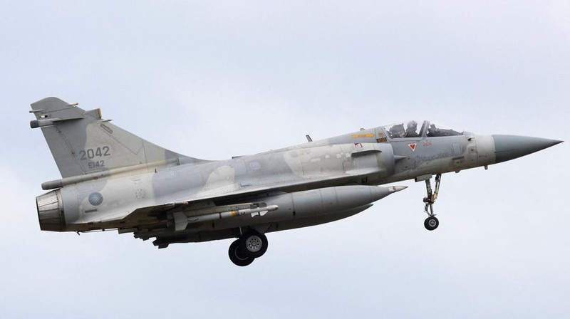 A person takes a photo of a flight information display screen that shows cancelled flights at the Taipei Songshan Airport, as China conducts 