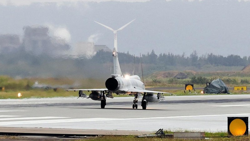 A person takes a photo of a flight information display screen that shows cancelled flights at the Taipei Songshan Airport, as China conducts 