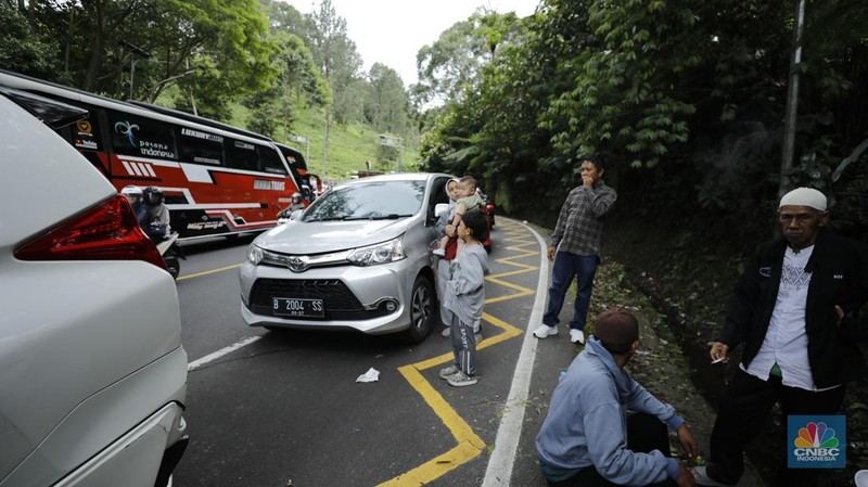 Pengendara terjebak kemacetan di Jalan Raya Puncak, Bogor, Jawa Barat, Selasa (30/12/2025). (CNBC Indonesia/Tri Susilo)