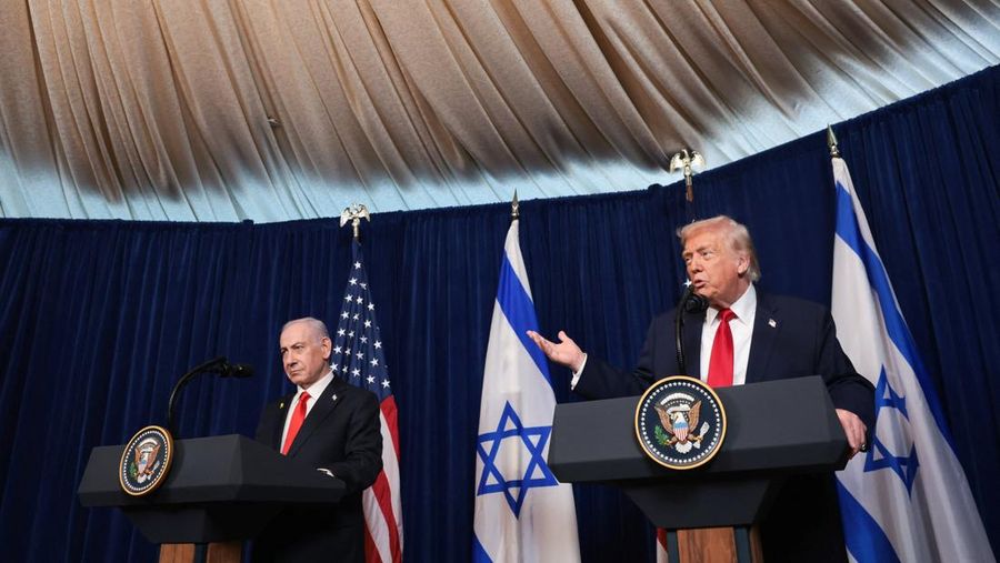 Presiden AS Donald Trump menunjuk ke arah Perdana Menteri Israel Benjamin Netanyahu saat mereka berjabat tangan dalam konferensi pers setelah bertemu di klub Mar-a-Lago milik Trump di Palm Beach, Florida, AS, Senin (29/12/2025). (REUTERS/Jonathan Ernst)