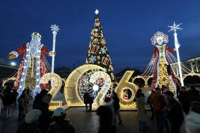 Orang-orang berkumpul di dekat dekorasi meriah yang dipasang untuk menyambut Tahun Baru dan liburan Natal di Simferopol, Krimea, 21 Desember 2025. REUTERS/Alexey Pavlishak