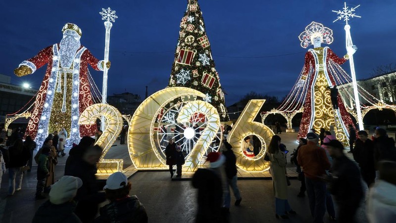 Orang-orang berkumpul di dekat dekorasi meriah yang dipasang untuk menyambut Tahun Baru dan liburan Natal di Simferopol, Krimea, 21 Desember 2025. REUTERS/Alexey Pavlishak