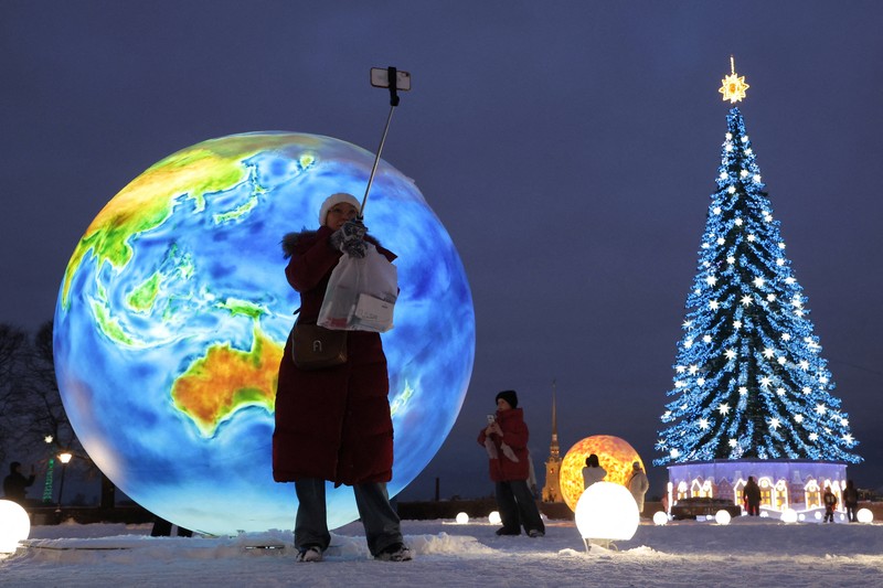 Orang-orang berkumpul di dekat dekorasi meriah yang dipasang untuk menyambut Tahun Baru dan liburan Natal di Simferopol, Krimea, 21 Desember 2025. REUTERS/Alexey Pavlishak