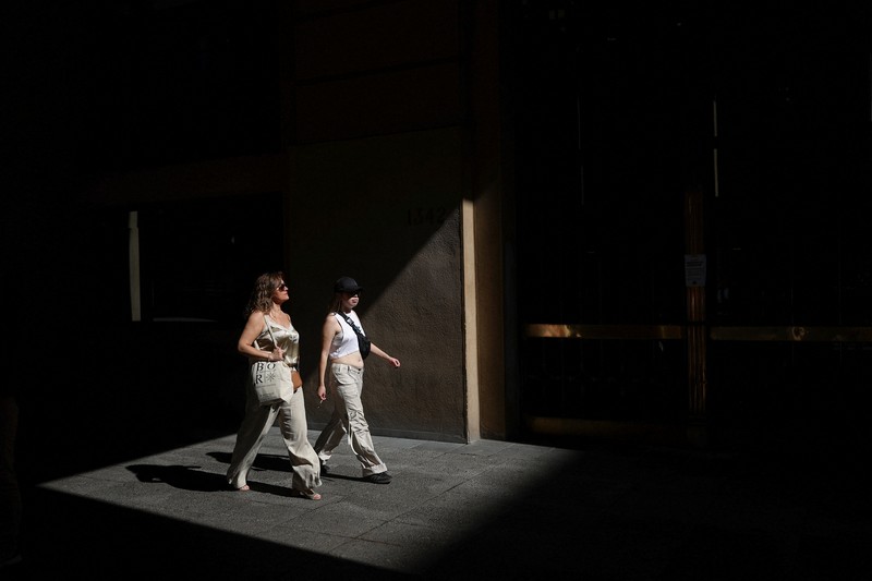 Dua wanita berjalan di bawah sinar matahari, saat gelombang panas di Santiago, Chili, 30 Desember 2025. (REUTERS/Pablo Sanhueza)