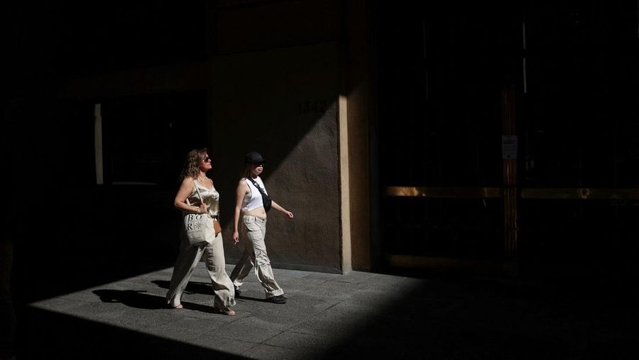 Dua wanita berjalan di bawah sinar matahari, saat gelombang panas di Santiago, Chili, 30 Desember 2025. (REUTERS/Pablo Sanhueza)