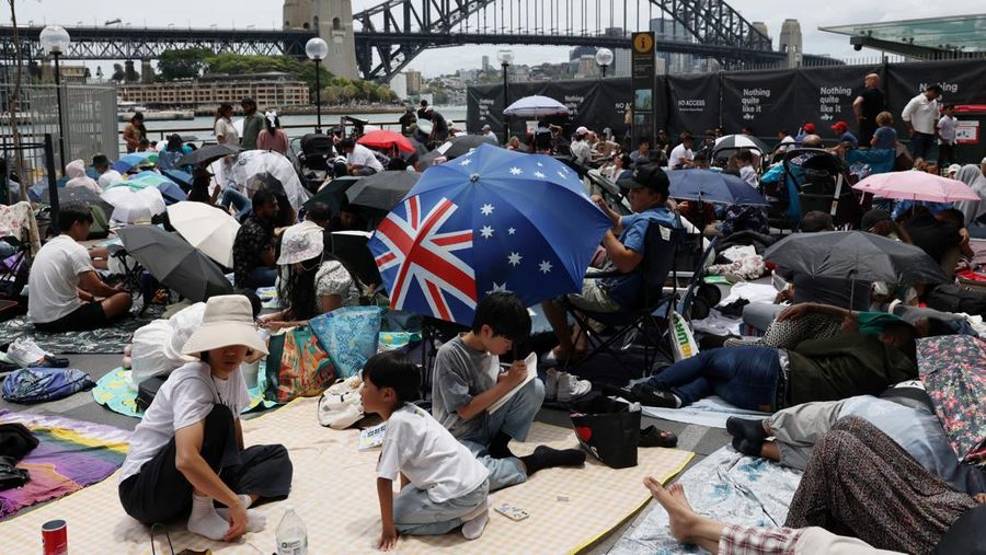 Orang-orang berkumpul di Circular Quay dekat Gedung Opera Sydney menjelang pertunjukan kembang api Malam Tahun Baru, di Sydney, Australia, 31 Desember 2025. (REUTERS/Hollie Adams)