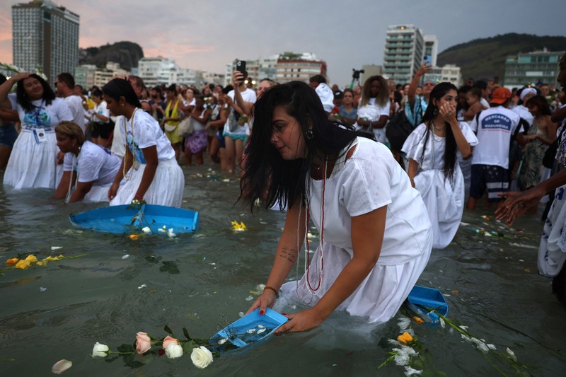 Sebuah tayangan drone menunjukkan para penganut agama Afro-Brasil memberikan penghormatan kepada Yemanja, dewi laut, selama perayaan malam Tahun Baru tradisional di Pantai Copacabana di Rio de Janeiro, Brasil, 29 Desember 2025. (REUTERS/Janaina Quinet)