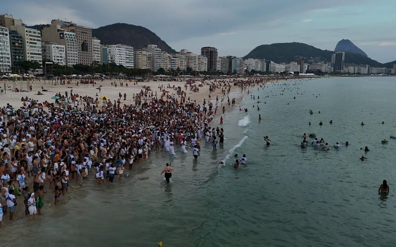 Sebuah tayangan drone menunjukkan para penganut agama Afro-Brasil memberikan penghormatan kepada Yemanja, dewi laut, selama perayaan malam Tahun Baru tradisional di Pantai Copacabana di Rio de Janeiro, Brasil, 29 Desember 2025. (REUTERS/Janaina Quinet)