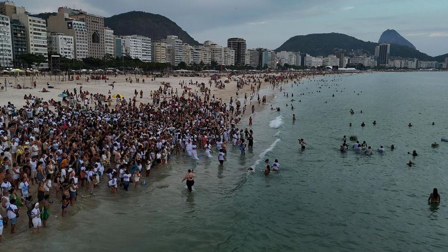 Sebuah tayangan drone menunjukkan para penganut agama Afro-Brasil memberikan penghormatan kepada Yemanja, dewi laut, selama perayaan malam Tahun Baru tradisional di Pantai Copacabana di Rio de Janeiro, Brasil, 29 Desember 2025. (REUTERS/Janaina Quinet)