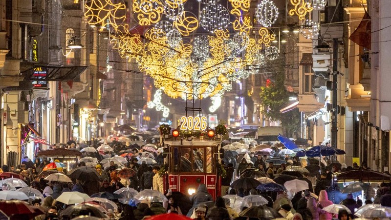 Orang-orang berkumpul di Circular Quay dekat Gedung Opera Sydney menjelang pertunjukan kembang api Malam Tahun Baru, di Sydney, Australia, 31 Desember 2025. (REUTERS/Hollie Adams)