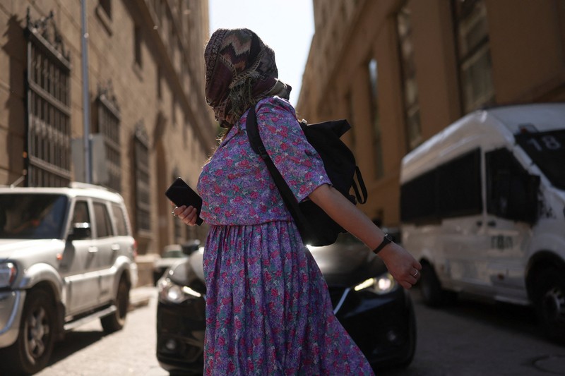 Dua wanita berjalan di bawah sinar matahari, saat gelombang panas di Santiago, Chili, 30 Desember 2025. (REUTERS/Pablo Sanhueza)