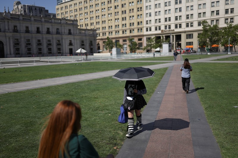 Dua wanita berjalan di bawah sinar matahari, saat gelombang panas di Santiago, Chili, 30 Desember 2025. (REUTERS/Pablo Sanhueza)