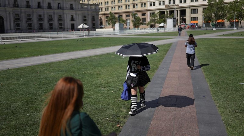 Dua wanita berjalan di bawah sinar matahari, saat gelombang panas di Santiago, Chili, 30 Desember 2025. (REUTERS/Pablo Sanhueza)