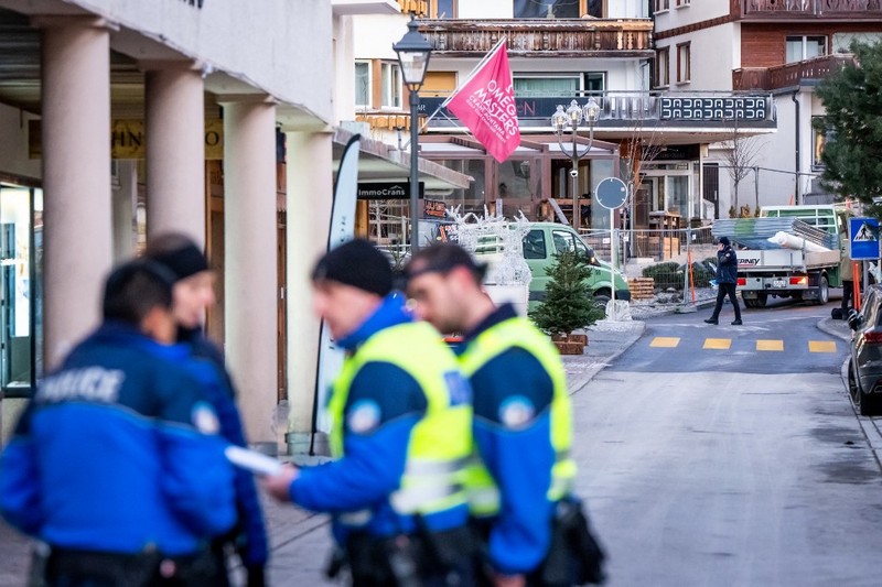 Petugas polisi terlihat di lokasi ledakan yang menghancurkan sebuah bar di Crans-Montana pada Kamis (1/1/2026). (AFP/MAXIME SCHMID)