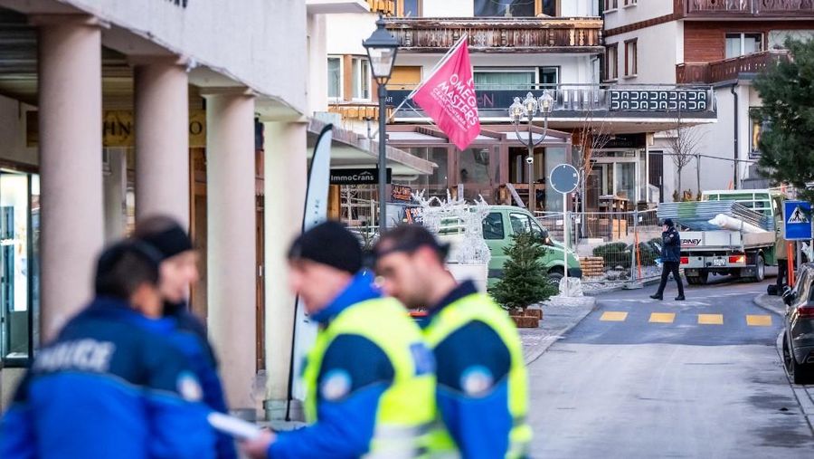 Petugas polisi terlihat di lokasi ledakan yang menghancurkan sebuah bar di Crans-Montana pada Kamis (1/1/2026). (AFP/MAXIME SCHMID)