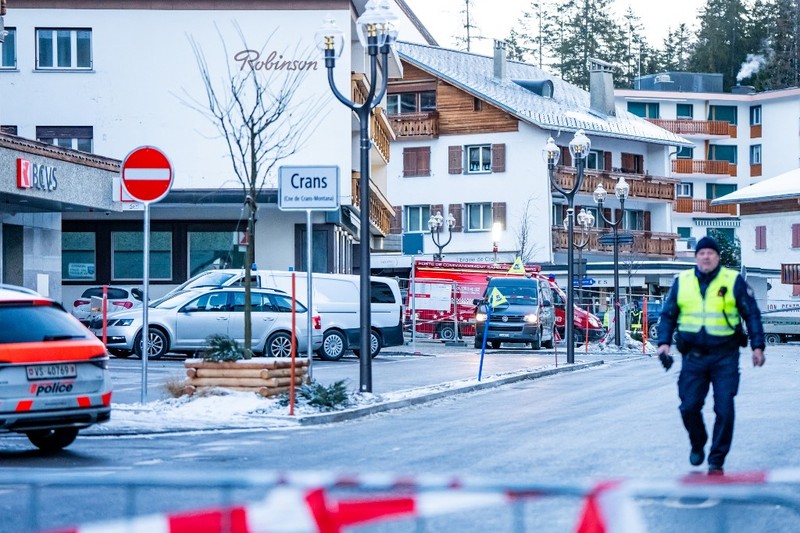 Petugas polisi terlihat di lokasi ledakan yang menghancurkan sebuah bar di Crans-Montana pada Kamis (1/1/2026). (AFP/MAXIME SCHMID)