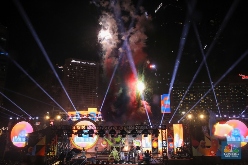 Warga menyaksikan atraksi formasi drone saat Perayaan Tahun Baru 2026 di Bundaran Hotel Indonesia (HI), Jakarta, Kamis (1/1/2026). (CNBC Indonesia/Faisal Rahman)