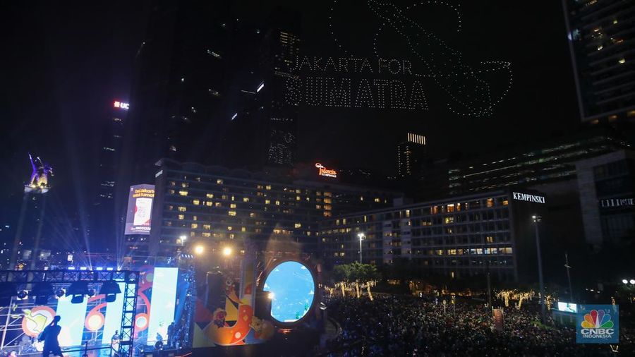 Warga menyaksikan atraksi formasi drone saat Perayaan Tahun Baru 2026 di Bundaran Hotel Indonesia (HI), Jakarta, Kamis (1/1/2026). (CNBC Indonesia/Faisal Rahman)
