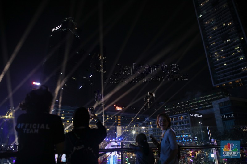 Warga menyaksikan atraksi formasi drone saat Perayaan Tahun Baru 2026 di Bundaran Hotel Indonesia (HI), Jakarta, Kamis (1/1/2026). (CNBC Indonesia/Faisal Rahman)