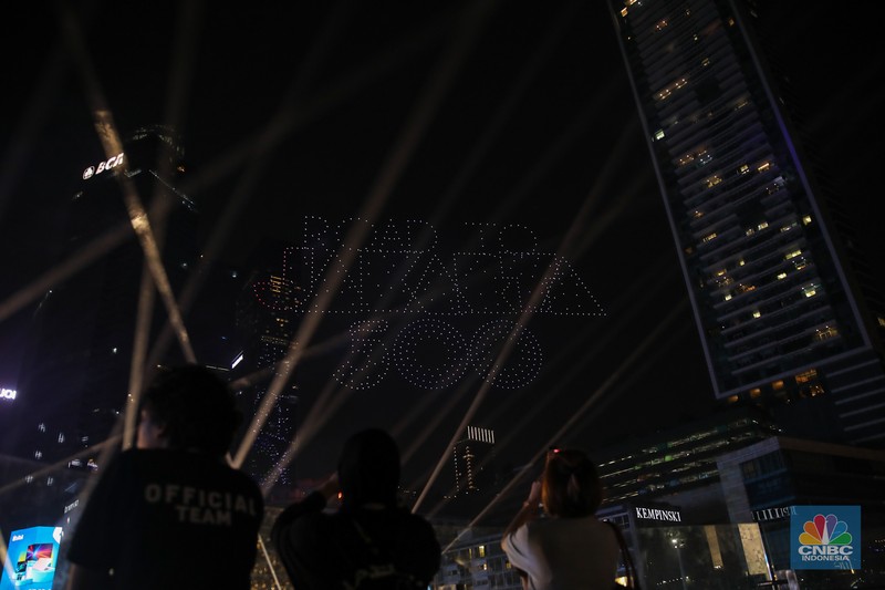 Warga menyaksikan atraksi formasi drone saat Perayaan Tahun Baru 2026 di Bundaran Hotel Indonesia (HI), Jakarta, Kamis (1/1/2026). (CNBC Indonesia/Faisal Rahman)