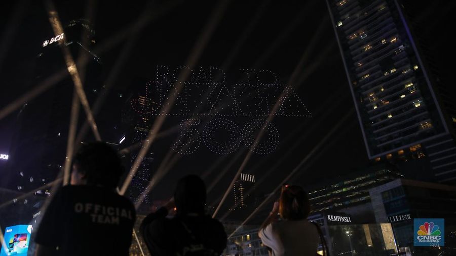Warga menyaksikan atraksi formasi drone saat Perayaan Tahun Baru 2026 di Bundaran Hotel Indonesia (HI), Jakarta, Kamis (1/1/2026). (CNBC Indonesia/Faisal Rahman)