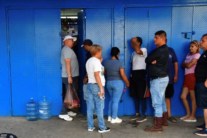People queue at a store to get groceries in Caracas on January 3, 2026, after US forces captured Venezuelan leader Nicolas Maduro. President Donald Trump said on January 3, 2026, that US forces had captured Venezuela's leader Nicolas Maduro after bombing the capital Caracas and other cities in a dramatic climax to a months-long standoff between Trump and his Venezuelan arch-foe. (Photo by Jacinto OLIVEROS / AFP)