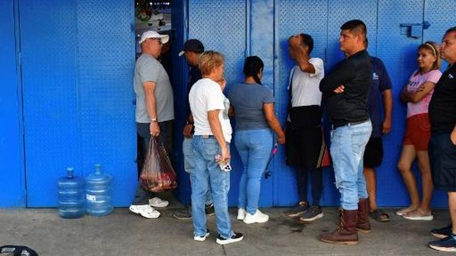People queue at a store to get groceries in Caracas on January 3, 2026, after US forces captured Venezuelan leader Nicolas Maduro. President Donald Trump said on January 3, 2026, that US forces had captured Venezuela's leader Nicolas Maduro after bombing the capital Caracas and other cities in a dramatic climax to a months-long standoff between Trump and his Venezuelan arch-foe. (Photo by Jacinto OLIVEROS / AFP)