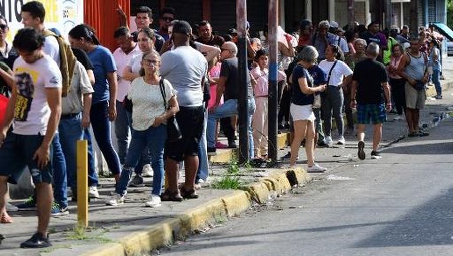 People queue at a store to get groceries in Caracas on January 3, 2026, after US forces captured Venezuelan leader Nicolas Maduro. President Donald Trump said on January 3, 2026, that US forces had captured Venezuela's leader Nicolas Maduro after bombing the capital Caracas and other cities in a dramatic climax to a months-long standoff between Trump and his Venezuelan arch-foe. (Photo by Jacinto OLIVEROS / AFP)
