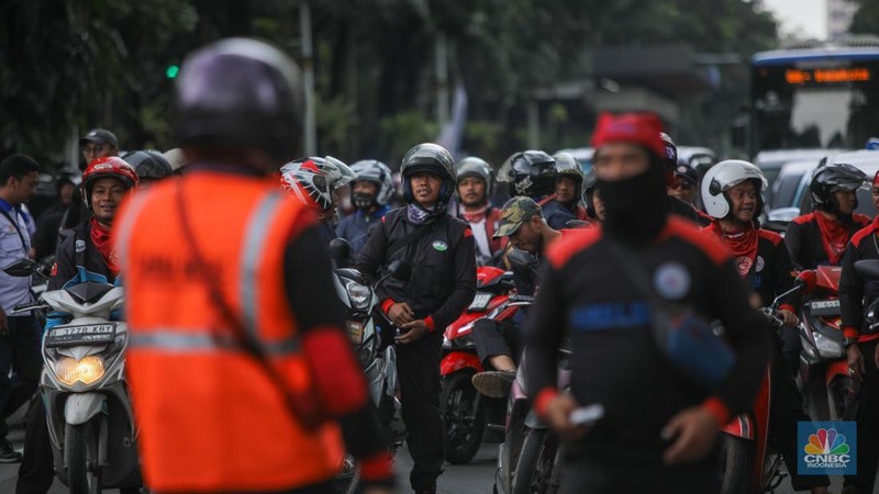 Buruh mengendarai sepeda motor saat tiba untuk melakukan unjuk rasa di kawasan Jalan Medan Merdeka Selatan, Jakarta, Kamis (8/1/2026). (CNBC Indonesia/Faisal Rahman)