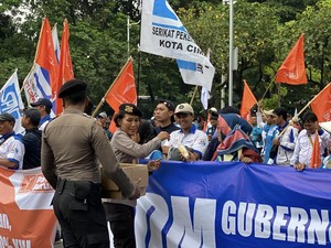 Polisi Bagikan Air Mineral dan Roti ke Massa Buruh di Monas