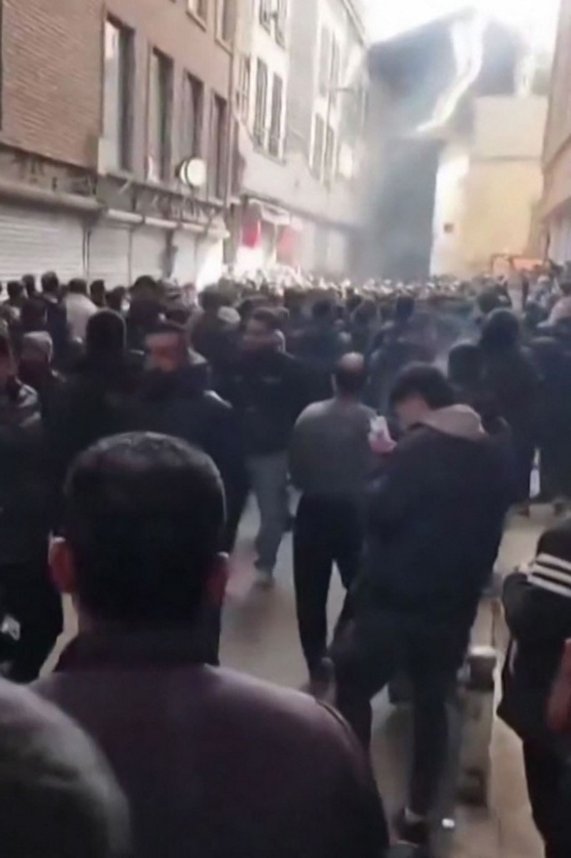 Sebuah mobil terbalik dan beberapa kebakaran terjadi saat para pengunjuk rasa meneriakkan slogan di luar kantor polisi, selama demonstrasi terbesar di Iran dalam tiga tahun terakhir terkait kesulitan ekonomi, di Azna, Provinsi Lorestan, Iran, Jumat (2/1/2026). (Media Sosial/via REUTERS)