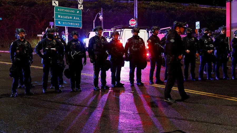 Seorang demonstran mengibarkan bendera Jolly Roger Bajak Laut Topi Jerami dari serial 