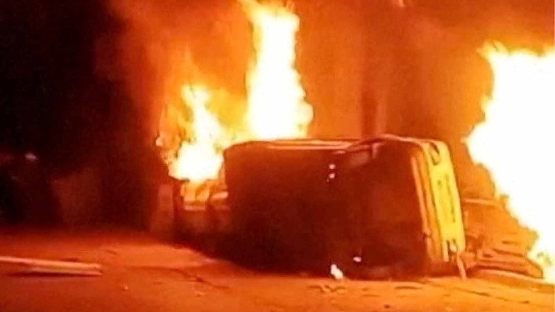 Sebuah mobil terbalik dan beberapa kebakaran terjadi saat para pengunjuk rasa meneriakkan slogan di luar kantor polisi, selama demonstrasi terbesar di Iran dalam tiga tahun terakhir terkait kesulitan ekonomi, di Azna, Provinsi Lorestan, Iran, Jumat (2/1/2026). (Media Sosial/via REUTERS)