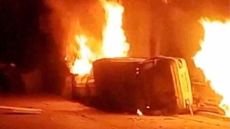 Sebuah mobil terbalik dan beberapa kebakaran terjadi saat para pengunjuk rasa meneriakkan slogan di luar kantor polisi, selama demonstrasi terbesar di Iran dalam tiga tahun terakhir terkait kesulitan ekonomi, di Azna, Provinsi Lorestan, Iran, Jumat (2/1/2026). (Media Sosial/via REUTERS)