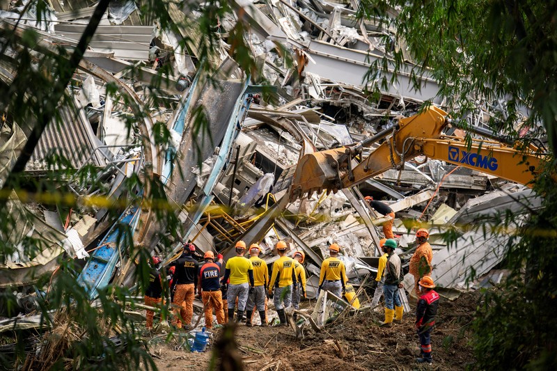 Petugas penyelamat melakukan operasi penyelamatan di lokasi runtuhnya tempat pembuangan sampah di Binaliw, Cebu, Filipina, Minggu (11/1/2026). (REUTERS/Lisa Marie David)