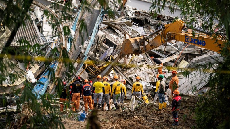 Petugas penyelamat melakukan operasi penyelamatan di lokasi runtuhnya tempat pembuangan sampah di Binaliw, Cebu, Filipina, Minggu (11/1/2026). (REUTERS/Lisa Marie David)
