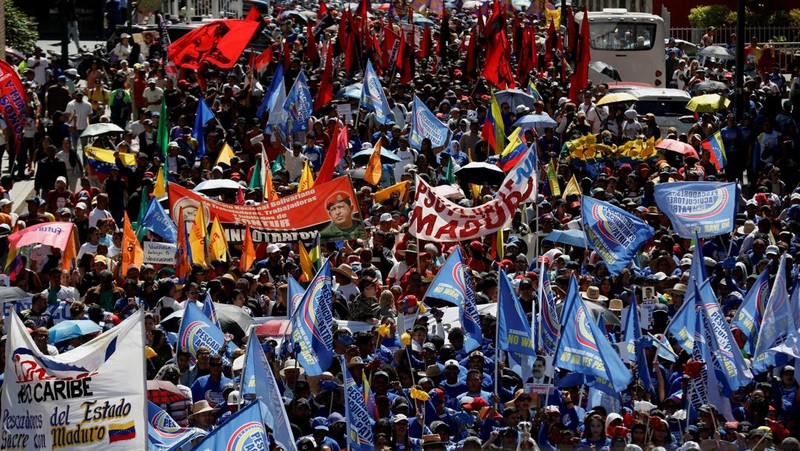 Ribuan warga berkumpul di berbagai wilayah Caracas sambil melambaikan bendera nasional dan memegang foto pasangan itu, menyerukan agar Maduro dan Flores dibebaskan dari tahanan. Aksi massa ini berlangsung di tengah ketegangan politik dan gejolak yang terus bergulir di negara tersebut. (REUTERS/Fausto Torrealba)
