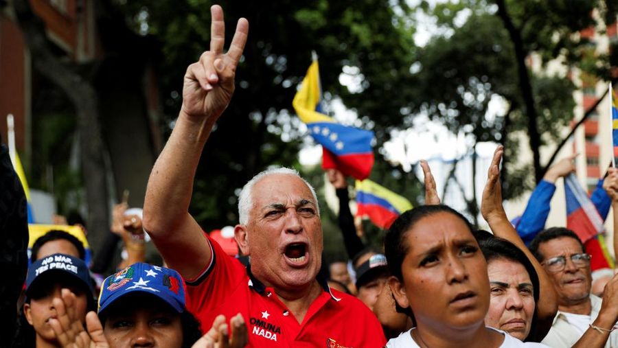 Ribuan warga berkumpul di berbagai wilayah Caracas sambil melambaikan bendera nasional dan memegang foto pasangan itu, menyerukan agar Maduro dan Flores dibebaskan dari tahanan. Aksi massa ini berlangsung di tengah ketegangan politik dan gejolak yang terus bergulir di negara tersebut. (REUTERS/Fausto Torrealba)