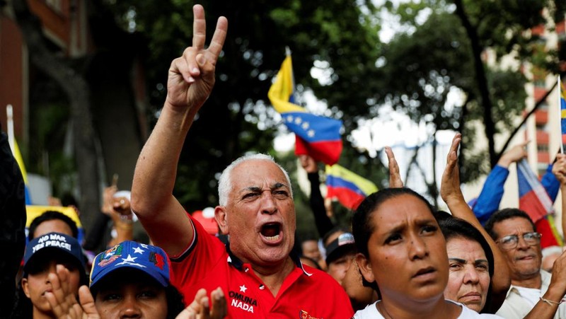 Ribuan warga berkumpul di berbagai wilayah Caracas sambil melambaikan bendera nasional dan memegang foto pasangan itu, menyerukan agar Maduro dan Flores dibebaskan dari tahanan. Aksi massa ini berlangsung di tengah ketegangan politik dan gejolak yang terus bergulir di negara tersebut. (REUTERS/Fausto Torrealba)