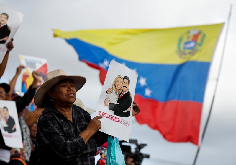 Ribuan warga berkumpul di berbagai wilayah Caracas sambil melambaikan bendera nasional dan memegang foto pasangan itu, menyerukan agar Maduro dan Flores dibebaskan dari tahanan. Aksi massa ini berlangsung di tengah ketegangan politik dan gejolak yang terus bergulir di negara tersebut. (REUTERS/Fausto Torrealba)