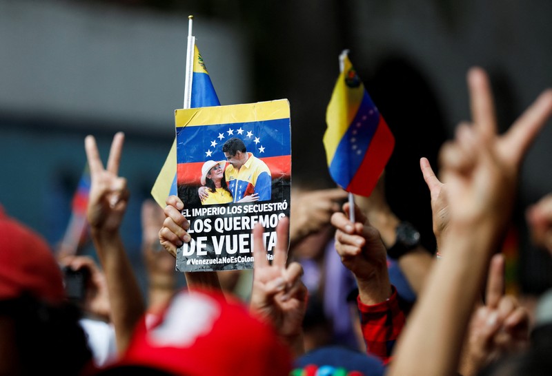 Ribuan warga berkumpul di berbagai wilayah Caracas sambil melambaikan bendera nasional dan memegang foto pasangan itu, menyerukan agar Maduro dan Flores dibebaskan dari tahanan. Aksi massa ini berlangsung di tengah ketegangan politik dan gejolak yang terus bergulir di negara tersebut. (REUTERS/Fausto Torrealba)