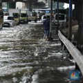 Pengendara sepeda motor melewati banjir di depan pintu masuk Taman Impian Jaya Ancol (pintu barat)di Pademangan, Jakarta, Senin (12/1/2026). (CNBC Indonesia/Tri Susilo)