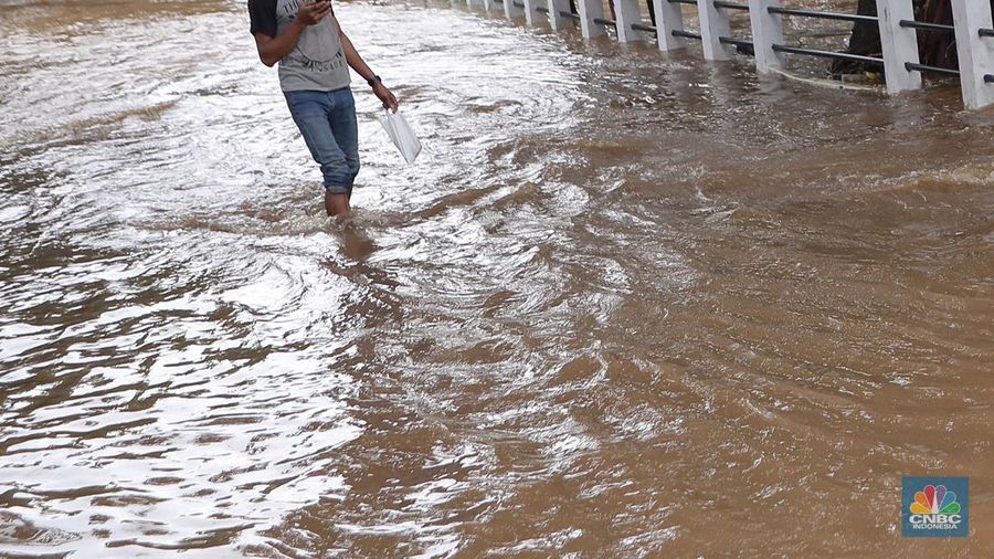 Petugas Sumber Daya Air (SDA) tampak mengangkat tumpukan sampah yang tersangkut di aliran Kali Krukut, kawasan Perumahan Puri Mutiara, Cilandak, Jakarta Selatan, Senin (12/1/2026). (CNBC Indonesia/Muhammad Sabki)