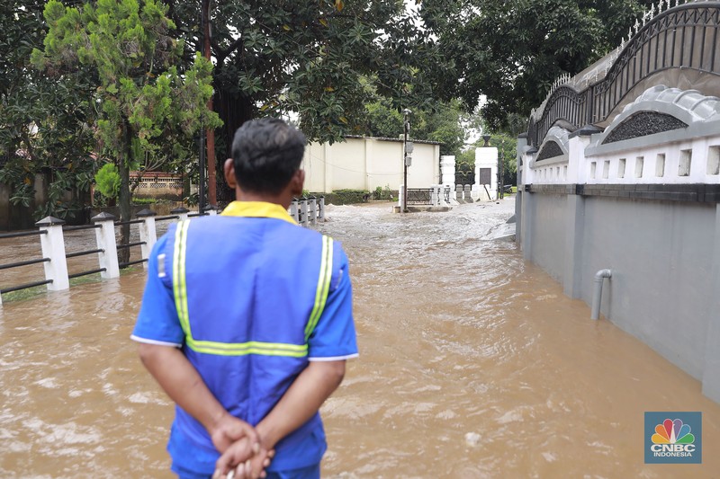 Petugas Sumber Daya Air (SDA) tampak mengangkat tumpukan sampah yang tersangkut di aliran Kali Krukut, kawasan Perumahan Puri Mutiara, Cilandak, Jakarta Selatan, Senin (12/1/2026). (CNBC Indonesia/Muhammad Sabki)