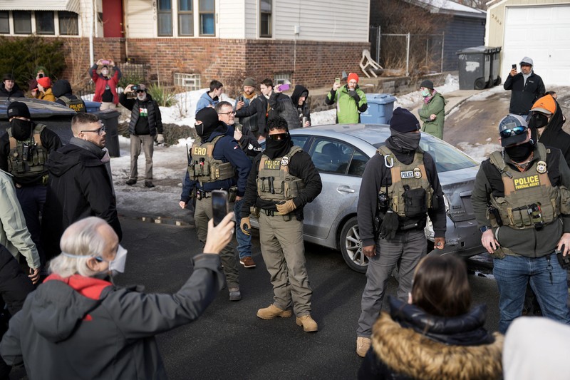 Agen Imigrasi dan Bea Cukai AS (ICE) berdiri di samping mobil warga sipil yang rusak akibat ditabrak oleh ICE, setelah seorang agen ICE menembak mati Renee Nicole Good, di Minneapolis, Minnesota, AS, 12 Januari 2026. (REUTERS/Tim Evans)